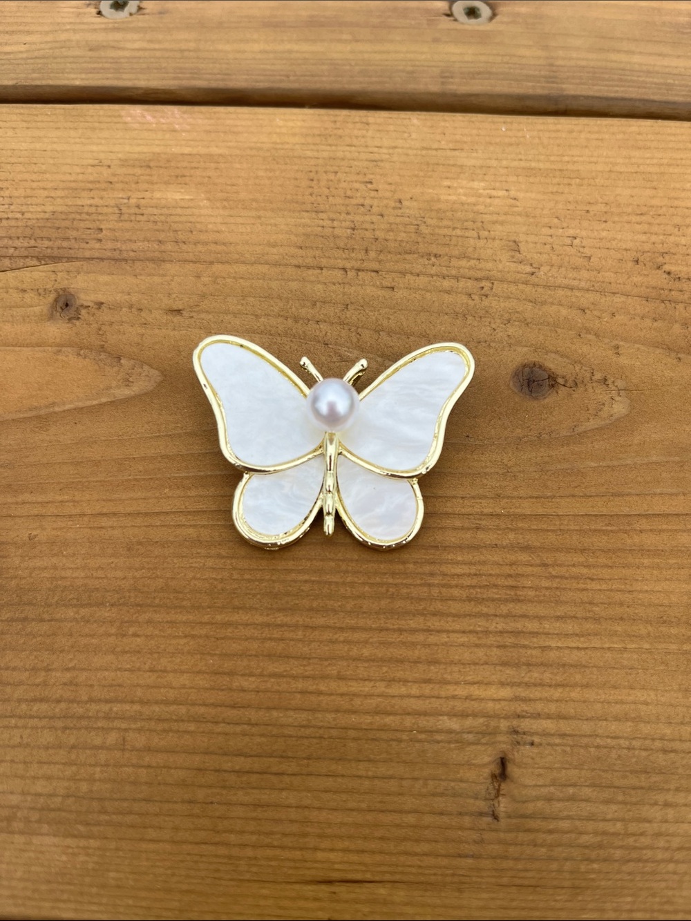 Gold tone butterfly brooch with mother of pearl style wings